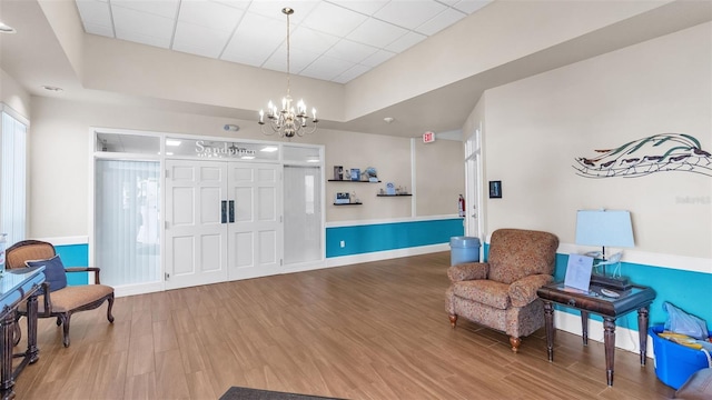 living area featuring hardwood / wood-style flooring and a chandelier