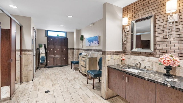 bathroom featuring vanity and tile walls