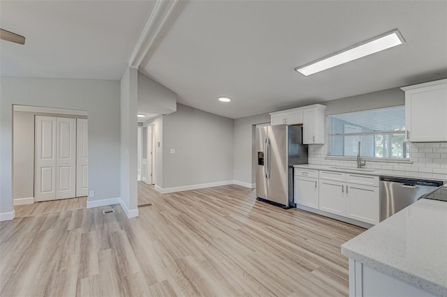 kitchen with white cabinetry, stainless steel appliances, and decorative backsplash