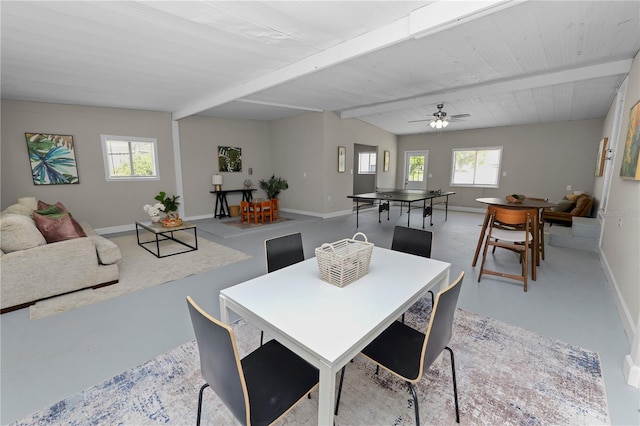 dining room with ceiling fan, a healthy amount of sunlight, and beam ceiling