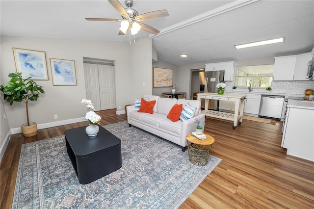 living room with hardwood / wood-style floors, vaulted ceiling, and ceiling fan