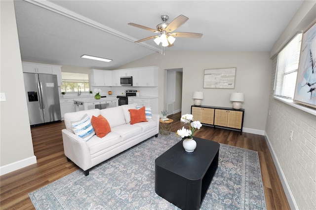 living room featuring lofted ceiling, dark hardwood / wood-style floors, sink, and ceiling fan