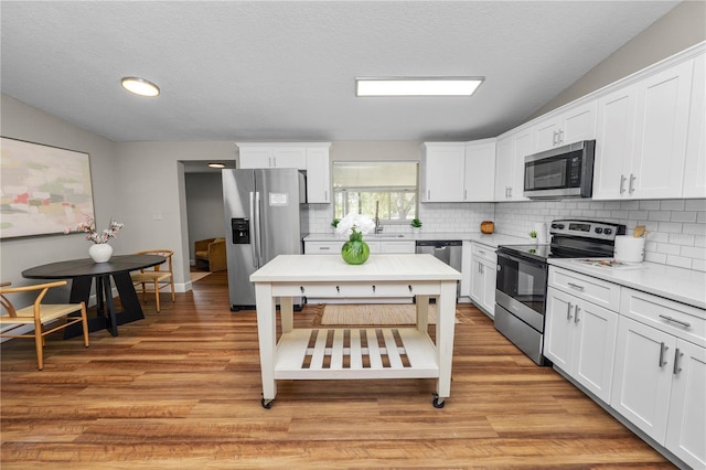 kitchen with white cabinetry, light hardwood / wood-style flooring, and stainless steel appliances