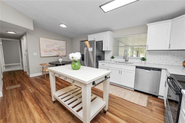 kitchen featuring tasteful backsplash, sink, white cabinets, and appliances with stainless steel finishes