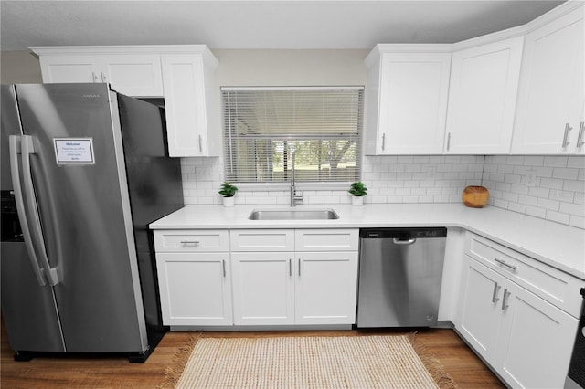 kitchen with sink, light hardwood / wood-style flooring, white cabinets, and appliances with stainless steel finishes