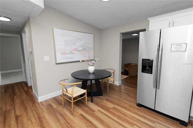 dining space with lofted ceiling and light hardwood / wood-style floors