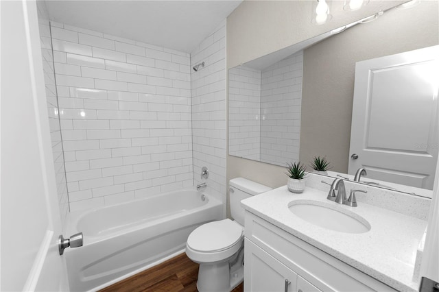 full bathroom featuring wood-type flooring, toilet, tiled shower / bath combo, and vanity