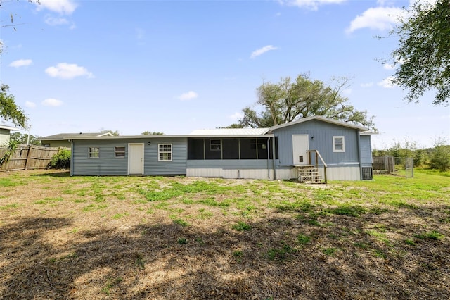 back of house with a yard and a sunroom