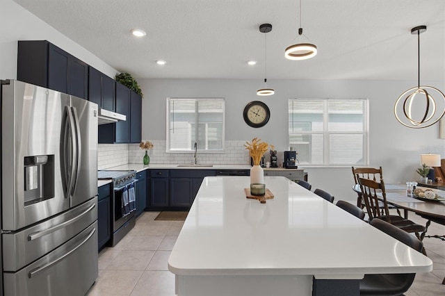 kitchen featuring blue cabinetry, stainless steel appliances, sink, and plenty of natural light