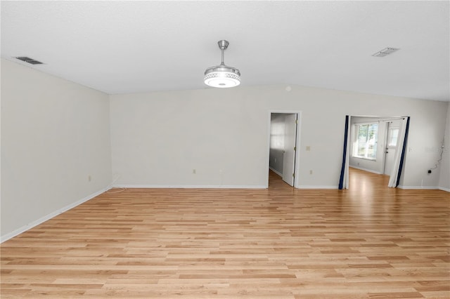 unfurnished room featuring light wood-type flooring and vaulted ceiling