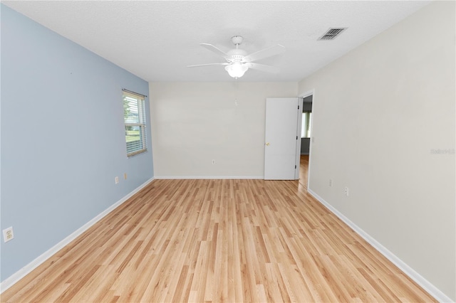 spare room with light hardwood / wood-style floors, a textured ceiling, and ceiling fan