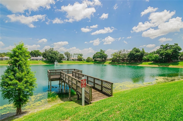 view of dock with a water view and a lawn