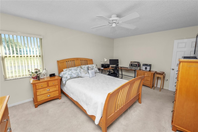 carpeted bedroom with ceiling fan and a textured ceiling