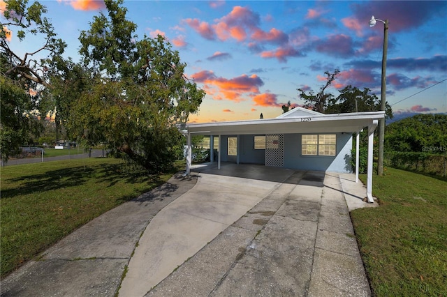 view of front of home with a yard and a carport