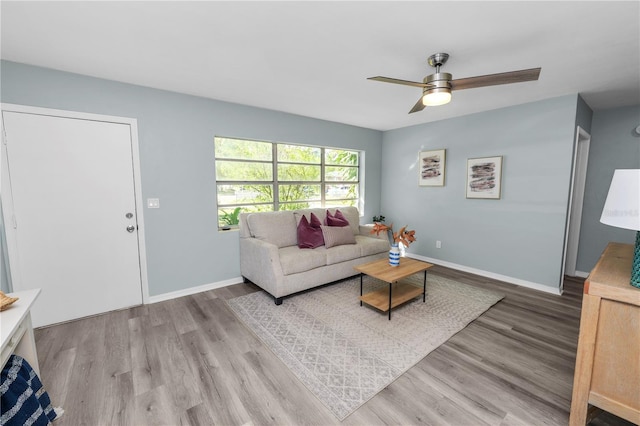 living room with light hardwood / wood-style floors and ceiling fan