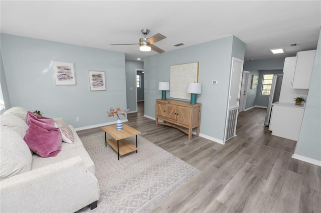 living room featuring ceiling fan and light hardwood / wood-style flooring