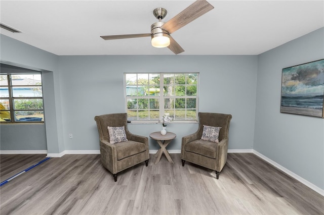 living area featuring a healthy amount of sunlight, light wood-type flooring, and ceiling fan