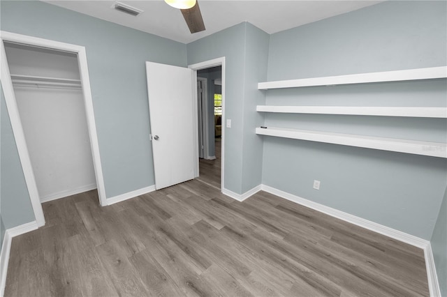 unfurnished bedroom with light hardwood / wood-style flooring, a closet, and ceiling fan