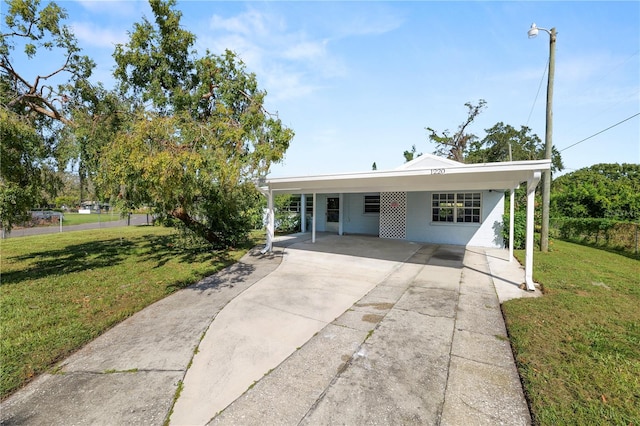 view of front of house with a carport and a front lawn