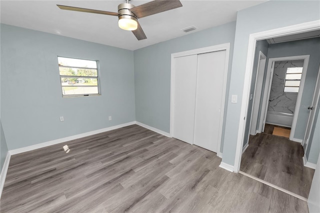 1220 Woodland Ave, Lakeland, FL 33801 - unfurnished bedroom featuring a closet, wood finished floors, attic access, and ceiling fan