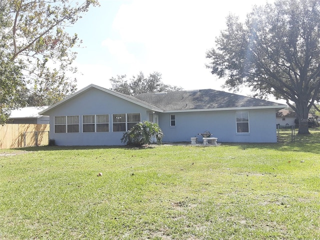 rear view of property featuring a lawn