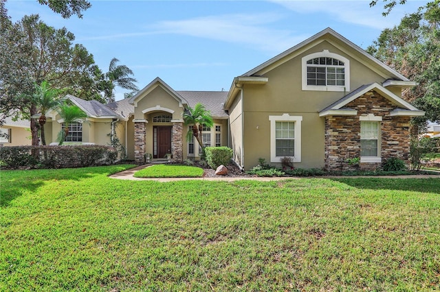 view of front of home with a front yard, stone siding, and stucco siding