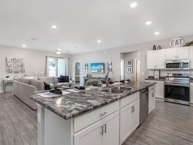 kitchen with white cabinetry, light hardwood / wood-style floors, appliances with stainless steel finishes, and sink