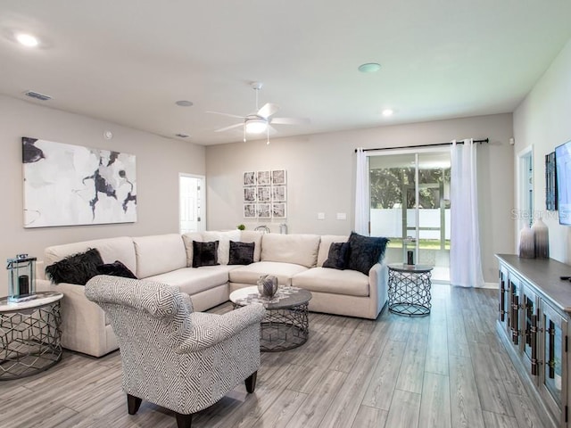 living room featuring light hardwood / wood-style floors and ceiling fan