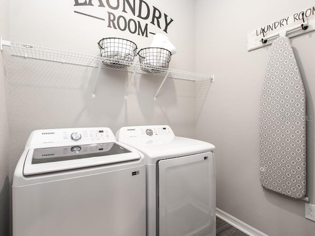 laundry room with wood-type flooring and washing machine and clothes dryer