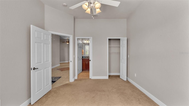 unfurnished bedroom featuring ceiling fan, light colored carpet, and a closet