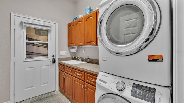 laundry room featuring cabinets, stacked washer / dryer, and sink