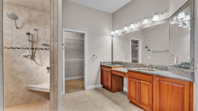 bathroom featuring vanity, tile patterned floors, and a tile shower