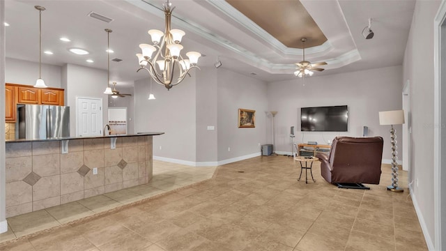 living room with ceiling fan with notable chandelier, light tile patterned floors, sink, crown molding, and a tray ceiling