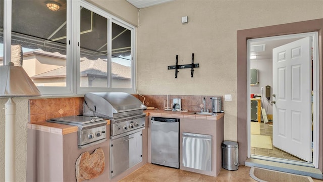 view of patio with an outdoor kitchen, a grill, and sink