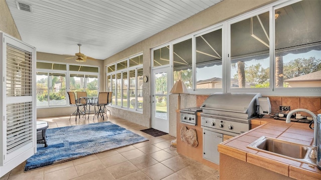 sunroom featuring sink and ceiling fan