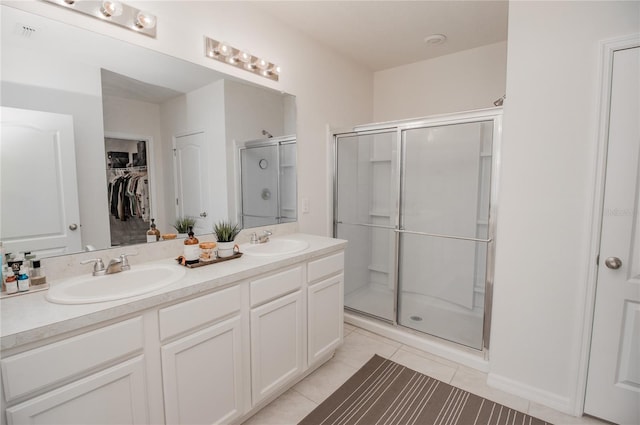 bathroom featuring vanity, a shower with shower door, and tile patterned floors