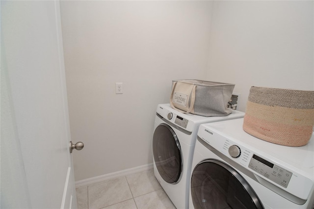 laundry room featuring washer and clothes dryer and light tile patterned floors