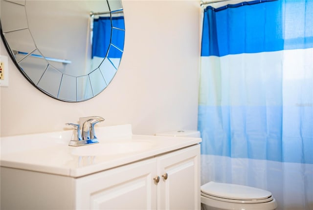 bathroom featuring toilet, walk in shower, and vanity