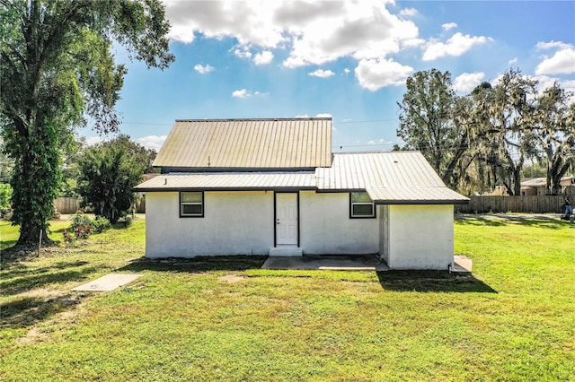 back of property with a lawn