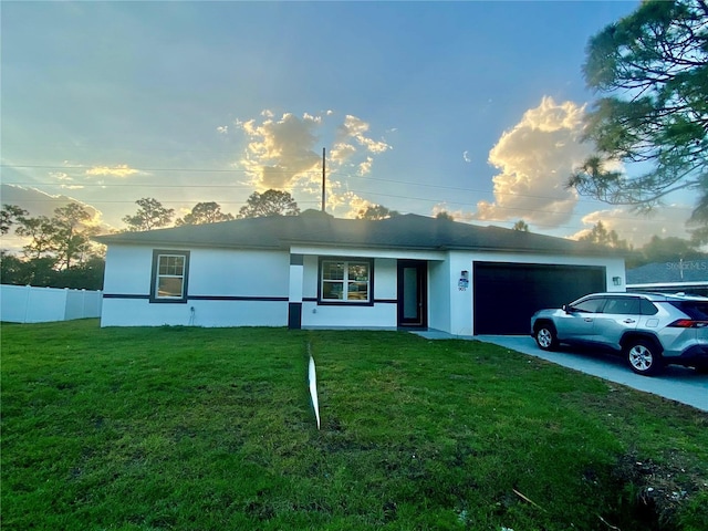 ranch-style house with driveway, an attached garage, fence, and stucco siding