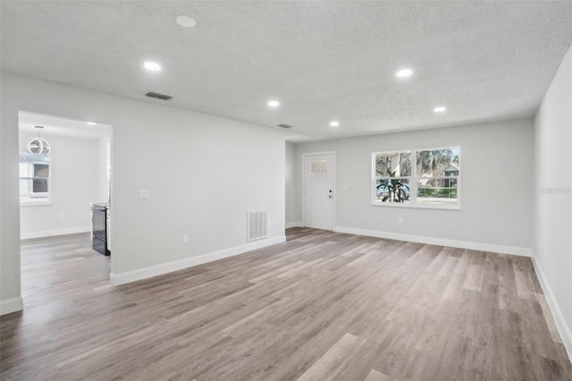 unfurnished room featuring a textured ceiling and wood-type flooring