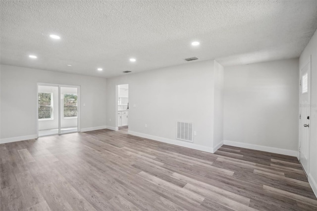 empty room featuring hardwood / wood-style flooring and a textured ceiling