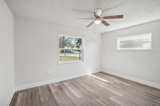 empty room with light hardwood / wood-style floors, a textured ceiling, and ceiling fan