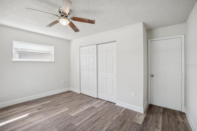 unfurnished bedroom featuring ceiling fan, a textured ceiling, and hardwood / wood-style floors