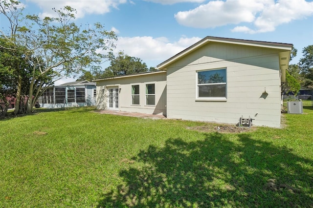 back of house featuring french doors, central air condition unit, and a lawn