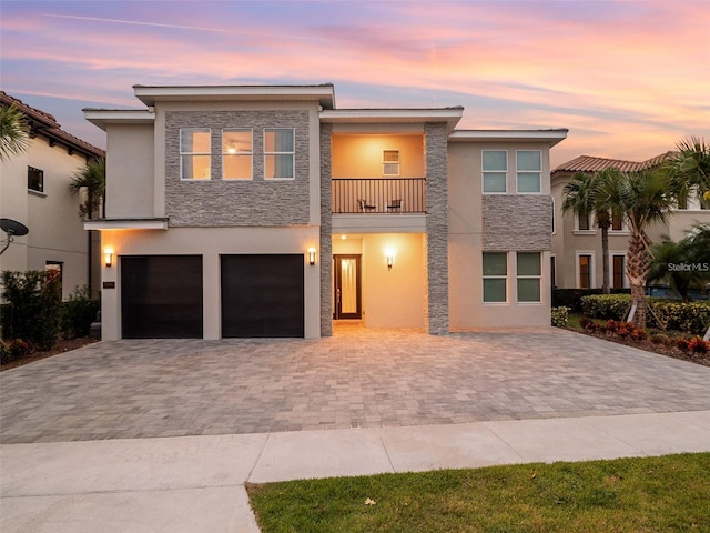 view of front of property featuring a balcony and a garage