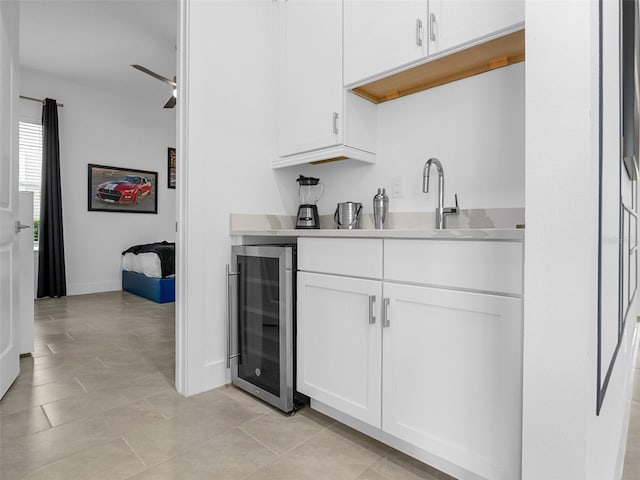 kitchen featuring white cabinetry, sink, beverage cooler, and light tile patterned floors