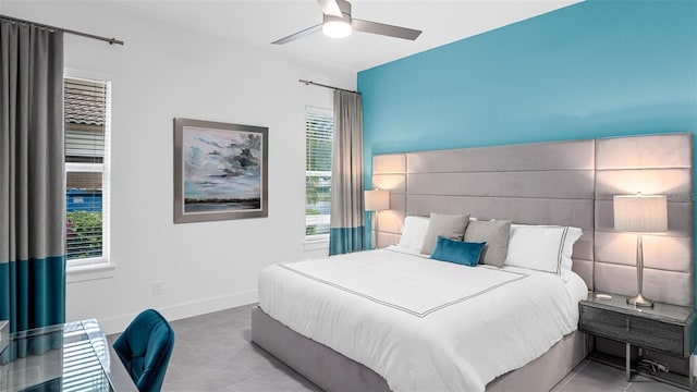 tiled bedroom featuring multiple windows and ceiling fan