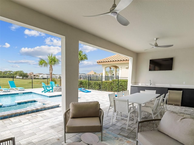 view of patio / terrace with sink, ceiling fan, and a swimming pool with hot tub