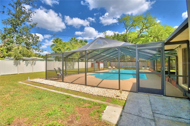 view of pool featuring a patio, glass enclosure, and a lawn